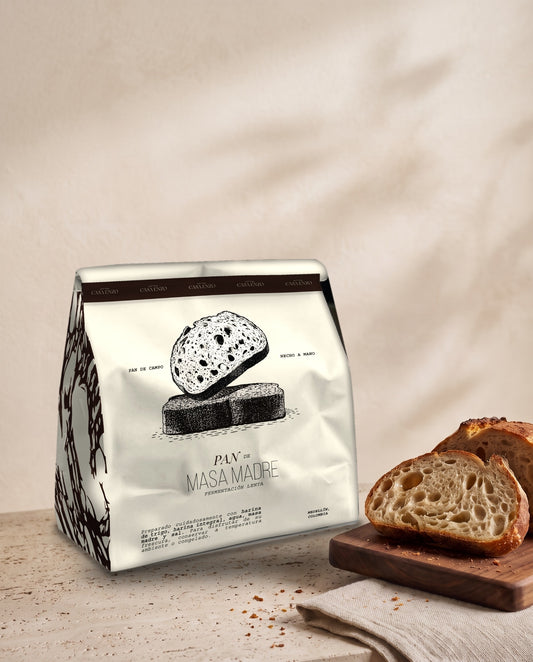 Bolsa de Pan de Masa Madre Casa Enzo, fermentación lenta, sobre travertino junto a tajadas de pan